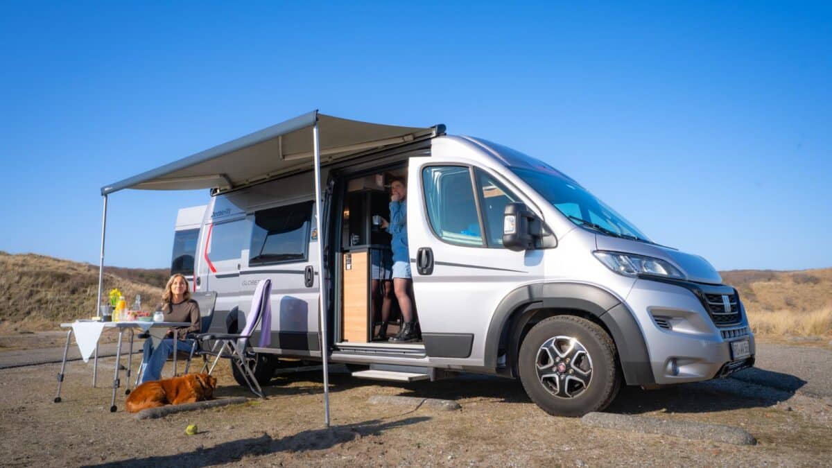 Freunde kochen gemeinsam am Wohnmobil w&auml;hrend ihres Urlaubs